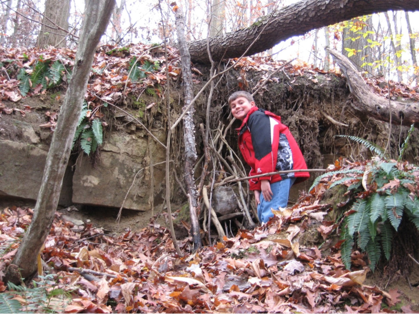 Boy at the elf house he has helped to build at Slate Run's natural play area.