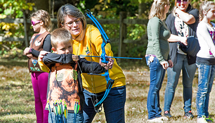 Archery Program boy and volunteer. Photo by Gil Sears. Archery Program boy and volunteer.
